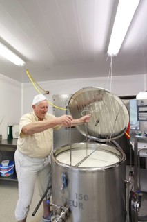 Cheesemaker during the production of goat cheese at the Goas-Alm cheese factory