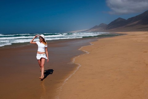 Woman walking along a sandy beach