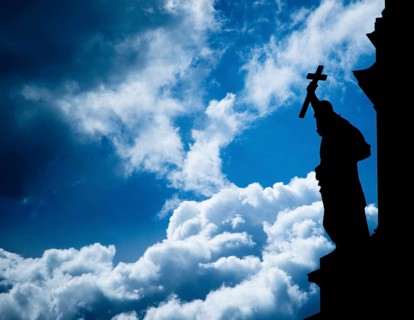 Silhouette of a sculpture holding a cross