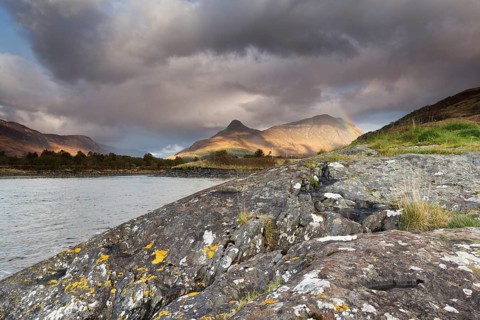Rainbow arching over the Pap of Glencoe or Sgorr na Ciche during unsettled weather