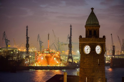 The Water Level Tower of the St. Pauli Landing Stages in front of the dry dock of the Blohm and Voss Shipyards with the ship Petrojarl Banff in the dock