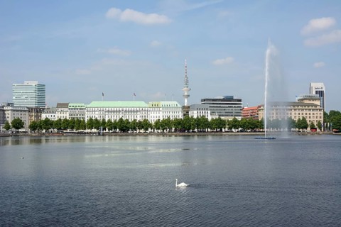 View over the Inner Alster Lake with Alster Fountain and an Alster swan towards the street of Neuer Jungfernstieg