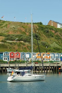 Sailing ship in the harbour of Heligoland or Helgoland in front of Hummerbuden or lobster shacks