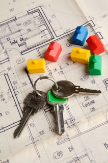 House keys and miniature houses on a construction plan