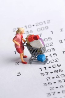 Miniature figurine of a woman with a shopping chart on a receipt