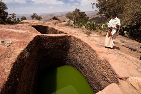 Orthodox monks at the holy water near the rock-hewn church of Mikael Imba
