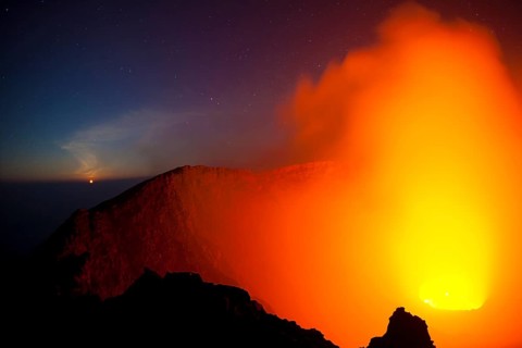 Moonset at the crater of the boiling lava lake of Mount Nyiragongo volcano