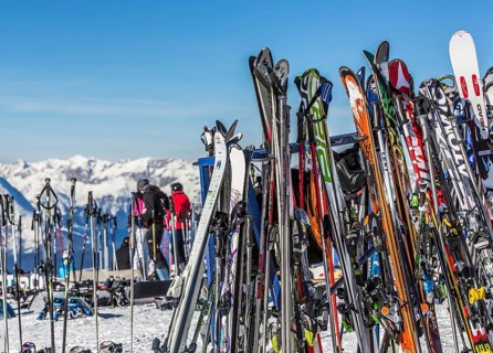 Skis and snowboards leaning against ski racks