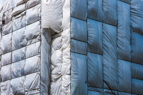 Scaffolding surrounded by a silver plastic tarp