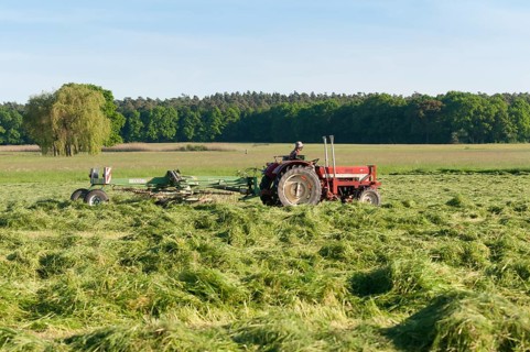 Tractor with hay turning machine