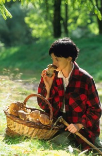 Woman with basket full of freshly picked mushrooms