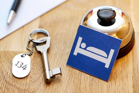 Bell and room key at a reception desk