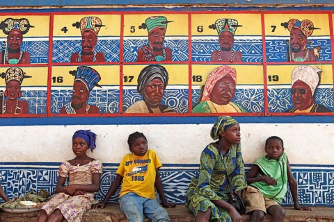 Boys and girls sitting in front of the row of ancestors on the Sultan's Palace of Foumban