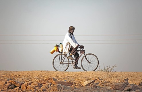 Local resident riding a bicycle at Maga Dam