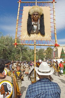 Man carrying an American Indian head on the sign of a dance group