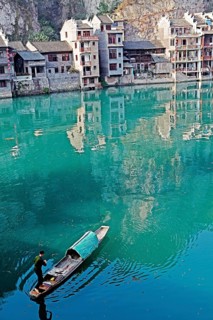 Houses and a fisherman in a boat on the jade-coloured Wuyang River