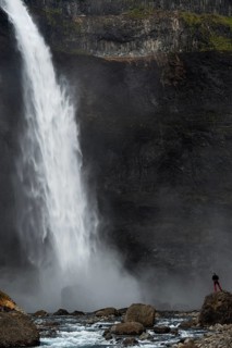 A tourist is standing at the Haifoss waterfall on the Fossa i Thjosardal river