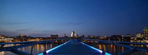 Millennium Bridge and London skyline at dusk