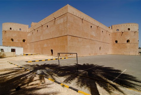 Al Hazm Castle behind the shadows of two palm trees