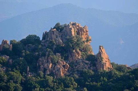 The typical bizarre red rocks of the Calanche of Piana below a blue sky. The Calanche of Piana is in the western part of the island Corsica