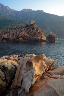 The Genoese Tower of Porto on top of a rocky hill and the Gulf of Porto