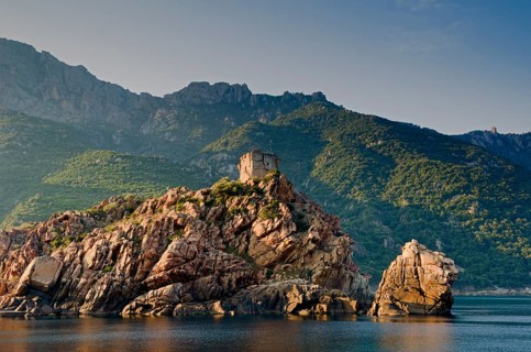 The Genoese Tower of Porto on top of a rocky hill and the Gulf of Porto
