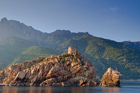 The Genoese Tower of Porto on top of a rocky hill and the Gulf of Porto
