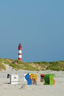 Beach with colourful beach chairs and a lighthouse