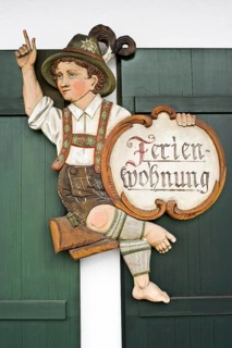 Carved wooden figure with a sign 'Ferienwohnung'