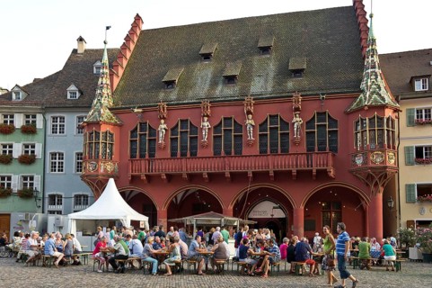 Wine stand and restaurants in front of the Historical Merchants Hall on Muensterplatz square or Cathedral Square