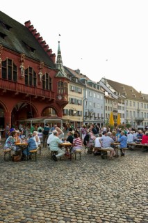 Wine stand and restaurants in front of the Historical Merchants Hall on Muensterplatz square or Cathedral Square