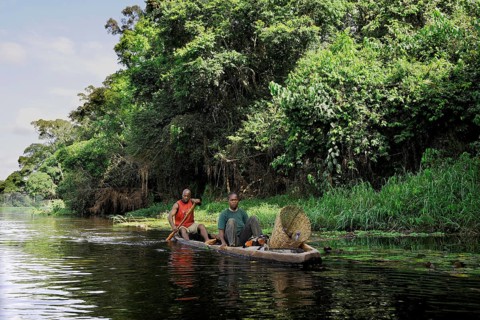 Fisherman travelling with his wife along the Nyong River to set fish traps