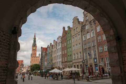 View through Green Gate or Brama Zielona towards the houses on Long Market or Dlugi Targ and the clock tower of Main Town Hall