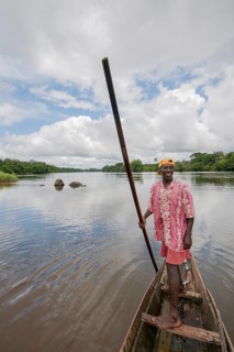 Man steering a pirogue on the Moa River at Tiwai Island Wildlife Sanctuary
