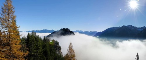 View from the ruins of Falkenstein Castle over the mist-covered Vilser Tal or Vils Valley and Zwoelferkogel mountain near Fuessen