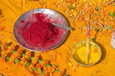 Colourpowder and coloured rice on yellow material to work with as a priest