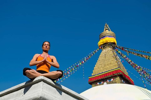 Young woman practicing yoga at Boudnanath stupa