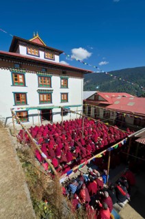 Many nuns wearing red cloths listening the teachings of Taklung Tsetru Rinpoche in the backyard of Junbesi Gompa