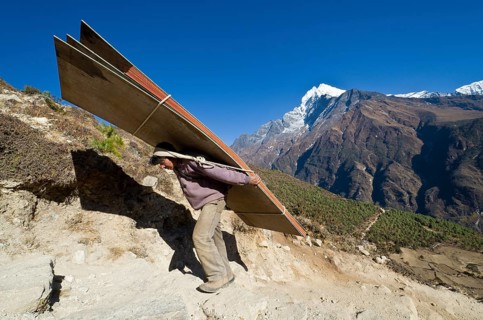 Porter carrying heavy load up an ascending track above Namche Bazar (3.440 m)
