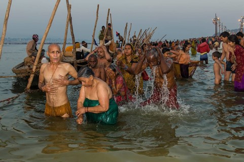 Crowds of people taking a bath in the Sangam