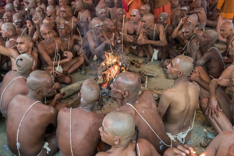 Sitting around a bonfire and chanting mantras as part of the initiation of new sadhus