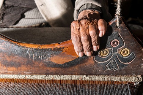 Old man weaving with a handloom