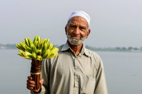 A local man holding a bunch of water lilies (Nymphaeaceae)