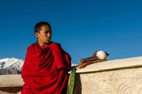 Monk on the roof of Thiksey Gompa monastery