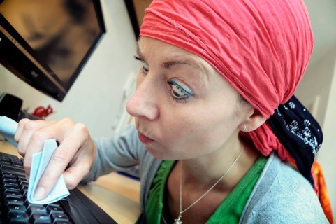 Cleaning lady cleaning a computer keyboard