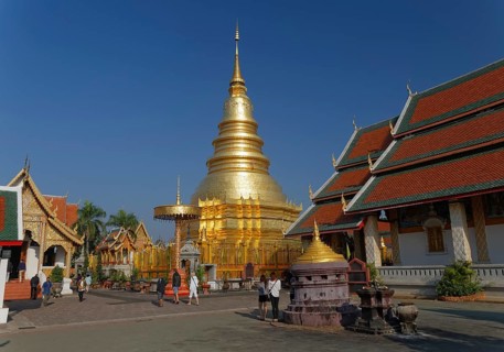 Golden chedi or pagoda with a ceremonial umbrella in the temple complex of Wat Phrathat Hariphunchai Woramahaviharn