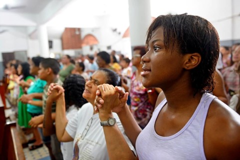 Worshippers holding each other's hands and praying