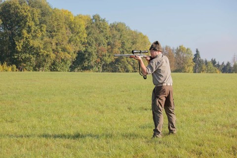 Hunter waiting for game with weapon at the ready