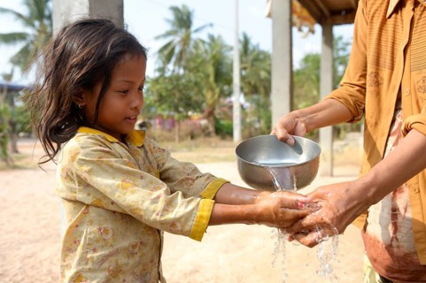 Woman washing a girl's hands