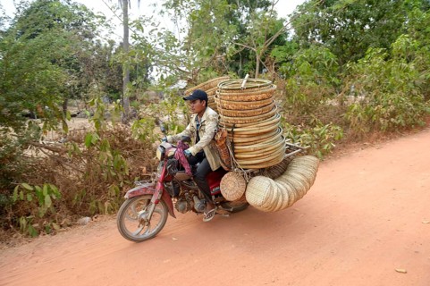 Man transporting baskets by motorbike to the market